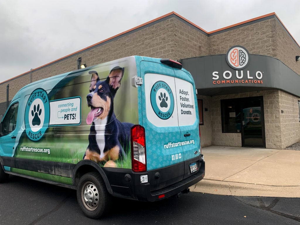 The Ruff Start Rescue transportation van is parked in front of the SOULO building. This van has a full vehicle wrap that was designed, manufactured and installed at SOULO